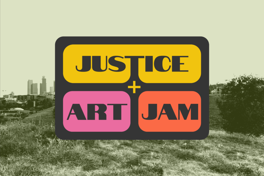 Logo for "Justice + Art Jam" placed on top of a photograph of Los Angeles. The logo, featuring the words "JUSTICE + ART JAM" in a sans-serif font within a dark gray rectangle with rounded corners, sits prominently at the center. Behind the logo, the image shows the Los Angeles skyline in the distance, with grassy hills and open fields in the foreground, depicting the Los Angeles State Historic Park. The bright yellow, pink, and red-orange accents of the logo contrast against the natural greens and urban tones of the background.